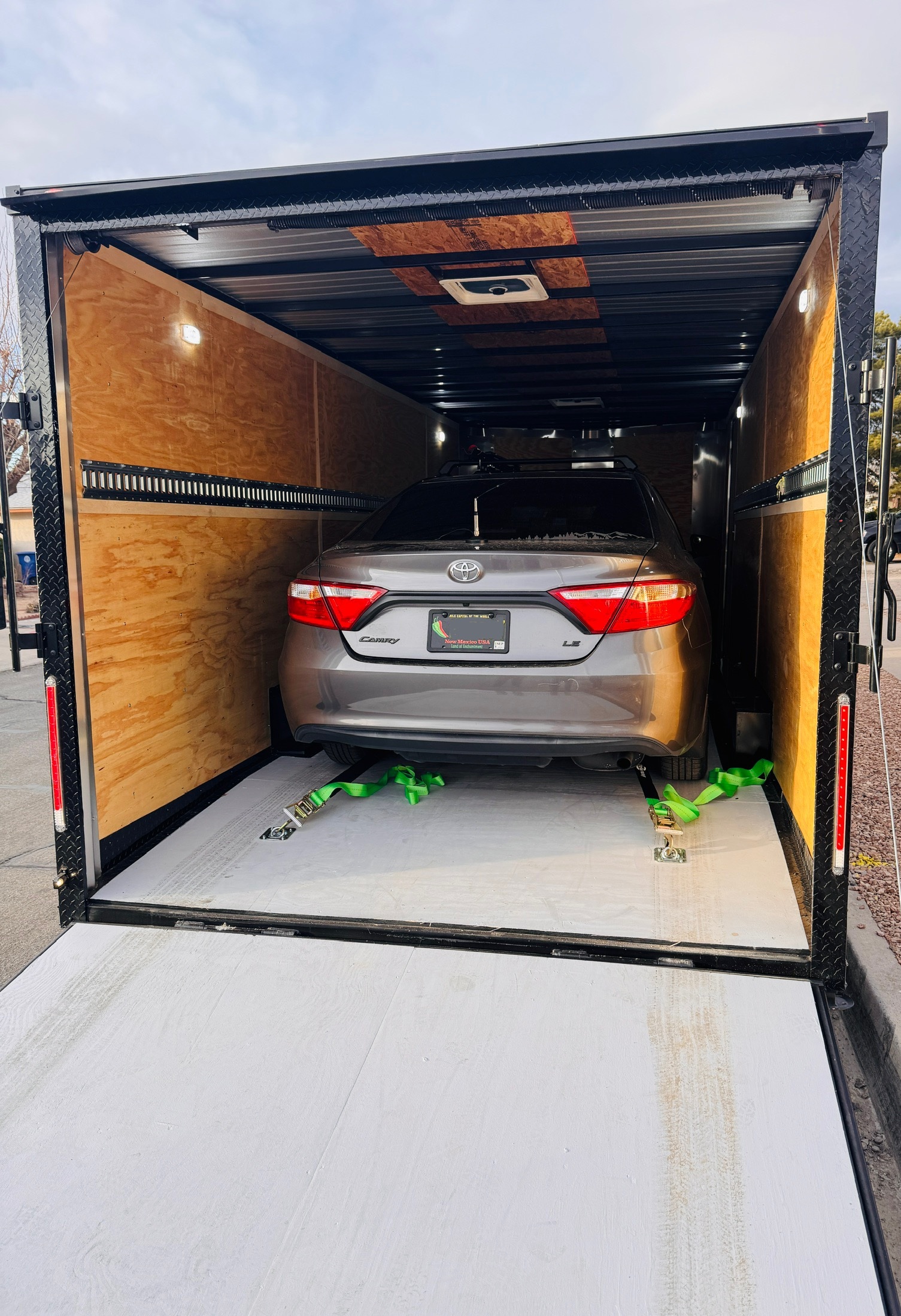 22ft enclosed cargo trailer interior with Toyota Camry loaded, showing backup camera system