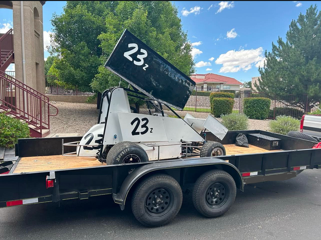 Utility trailer loaded with race car and equipment, available for rent in Albuquerque